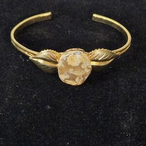 Gold-tone cuff bracelet featuring an oval-shaped flower agate Size 6